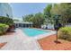 Beautiful in-ground pool with brick pavers, surrounded by lush landscaping and mature trees at 16 Golfview Ne Cir, Winter Haven, FL 33881