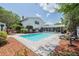 Exterior view of the in-ground pool and patio with comfortable lounge chairs and lush landscaping at 16 Golfview Ne Cir, Winter Haven, FL 33881
