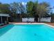 A refreshing swimming pool surrounded by privacy fencing and comfortable lounge chairs for relaxing poolside at 16 Golfview Ne Cir, Winter Haven, FL 33881