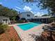 Inviting pool area with brick paver decking, lush landscaping, and a screened-in lanai for outdoor relaxation at 16 Golfview Ne Cir, Winter Haven, FL 33881