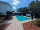 Backyard featuring a sparkling pool, brick paver patio, and lush, mature landscaping for serene outdoor living at 16 Golfview Ne Cir, Winter Haven, FL 33881