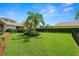Manicured backyard with green grass, trimmed hedges, and palm tree at 1772 Laurel Glen Pl, Lakeland, FL 33803