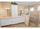 Bathroom featuring double sinks, granite counters, and a glass-enclosed shower at 1772 Laurel Glen Pl, Lakeland, FL 33803