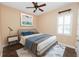 Cozy bedroom with a ceiling fan, neutral walls, stylish flooring, and bright, shuttered windows at 1772 Laurel Glen Pl, Lakeland, FL 33803