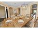 Dining room featuring a long wooden table with place settings, candles and bright chandelier at 1772 Laurel Glen Pl, Lakeland, FL 33803