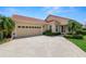 Attractive home exterior with a two-car garage, tile roof, and neatly trimmed landscaping at 1772 Laurel Glen Pl, Lakeland, FL 33803