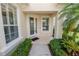 Inviting front porch featuring a glass door, manicured bushes, and a palm tree at 1772 Laurel Glen Pl, Lakeland, FL 33803