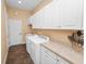 Practical laundry room with washer, dryer, white cabinets, and ample counter space at 1772 Laurel Glen Pl, Lakeland, FL 33803