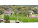 Picturesque aerial view of a lakeside home with a dock, surrounded by mature trees and well-manicured lawns at 1837 Farrington Dr, Lakeland, FL 33809
