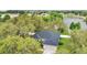 Aerial view of the house with a dark roof near the water, surrounded by mature trees, enhancing its peaceful charm at 1837 Farrington Dr, Lakeland, FL 33809