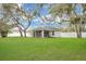 Well-maintained backyard with green lawn and home featuring a screened-in patio at 1837 Farrington Dr, Lakeland, FL 33809