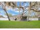 Scenic backyard featuring lush greenery, mature trees, and the home with a screened-in porch at 1837 Farrington Dr, Lakeland, FL 33809