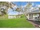 Expansive backyard with lush green lawn, lake view, and a screened-in patio at 1837 Farrington Dr, Lakeland, FL 33809