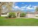 Lovely home with lush green lawn, beautiful trees, and an attached two-car garage at 1837 Farrington Dr, Lakeland, FL 33809