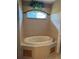 Bright bathroom featuring a tile surround soaking tub and garden window at 200 S Goodman Ave, Lake Alfred, FL 33850