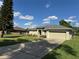 Well-manicured home exterior featuring a lovely green lawn and a long driveway at 200 S Goodman Ave, Lake Alfred, FL 33850
