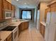 Open kitchen features white appliances, wooden cabinets, and a breakfast bar at 200 S Goodman Ave, Lake Alfred, FL 33850