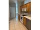 Well-lit kitchen features wooden cabinets, white appliances, and tile flooring at 200 S Goodman Ave, Lake Alfred, FL 33850