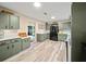 Bright kitchen with olive green cabinets, tile backsplash, and stainless-steel refrigerator at 209 W Crescent Dr, Lakeland, FL 33805
