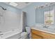 This bathroom features a bathtub, toilet, sink with wood cabinet, and a large mirror at 2173 Castle Pt, Winter Haven, FL 33880