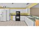 Bright kitchen featuring white cabinets, tile floors, and black appliances at 2173 Castle Pt, Winter Haven, FL 33880