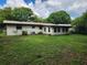 Back exterior of the house with an enclosed porch and large yard at 220 Pinehurst Dr, Auburndale, FL 33823