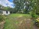 Large backyard with mature trees and plants, side of house at 220 Pinehurst Dr, Auburndale, FL 33823