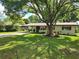 Charming single-story home with a well-maintained lawn and mature tree in the front yard at 220 Pinehurst Dr, Auburndale, FL 33823