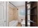 Bathroom featuring tiled walls, a tub, and natural light from a window at 236 Hillside Dr, Lakeland, FL 33803