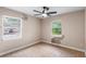 Bedroom featuring neutral walls, tiled flooring, ceiling fan, and natural light from two windows at 236 Hillside Dr, Lakeland, FL 33803