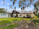 The home's back exterior featuring a lawn, patio, and unique roofline at 2500 Brooke Rd, Fort Meade, FL 33841