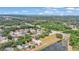 The aerial view showcases a suburban community near a pond, surrounded by lush, mature trees and landscaping at 2526 Fabry Cir, Orlando, FL 32817