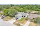 Aerial view of a suburban home with a large front yard, two-car garage, and surrounded by lush trees at 2526 Fabry Cir, Orlando, FL 32817