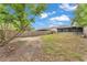 Expansive backyard view with a privacy fence, a screened-in patio, and mature trees providing shade at 2526 Fabry Cir, Orlando, FL 32817
