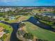 Aerial view featuring a scenic golf course, lake with fountain, and a community pool at 2569 Laurel Glen Dr, Lakeland, FL 33803