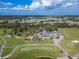 Aerial view of a sprawling golf course and a large clubhouse with golf carts at 2569 Laurel Glen Dr, Lakeland, FL 33803