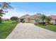 Well-maintained home with green lawn, mature trees, and a side garage at 2569 Laurel Glen Dr, Lakeland, FL 33803