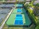 Aerial view showcasing bright blue and green pickleball courts and lush landscaping at 2569 Laurel Glen Dr, Lakeland, FL 33803