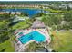 Aerial of the community pool, set among lush landscaping, lake, and tennis courts in a residential area at 2569 Laurel Glen Dr, Lakeland, FL 33803