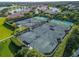 Aerial view of multiple well-maintained tennis courts with lush landscaping at 2569 Laurel Glen Dr, Lakeland, FL 33803