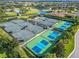 Aerial view of tennis and pickleball courts surrounded by trees and a nearby lake at 2569 Laurel Glen Dr, Lakeland, FL 33803