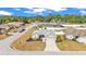 Aerial view of a well-maintained home with lush landscaping in a quiet residential neighborhood, featuring a grey roof at 2700 Oak Hammock Loop, Mulberry, FL 33860