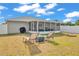 A backyard featuring lounge chairs and a screened in porch, perfect for relaxing and entertaining outdoors at 2700 Oak Hammock Loop, Mulberry, FL 33860