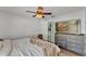Serene bedroom with a stylish gray dresser and large TV, perfect for relaxation and entertainment at 2700 Oak Hammock Loop, Mulberry, FL 33860