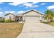 Charming single-story home with a well-manicured lawn, gray exterior and a two-car garage in a residential neighborhood at 2700 Oak Hammock Loop, Mulberry, FL 33860