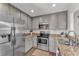 Modern kitchen featuring stainless steel appliances, granite countertops, and sleek gray cabinetry at 2700 Oak Hammock Loop, Mulberry, FL 33860