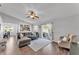 Open-concept living room with hardwood floors, access to the patio, and a view of the modern kitchen at 2700 Oak Hammock Loop, Mulberry, FL 33860