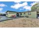 Spacious backyard with a wooden deck, gravel, and a red Adirondack chair at 2705 N Martha Ave, Lakeland, FL 33805