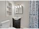 Updated bathroom featuring new vanity, white toilet, shelving, and a shower with patterned curtain at 2705 N Martha Ave, Lakeland, FL 33805