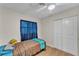 Bedroom with sliding closet door, hardwood floors, and blue curtains at 2705 N Martha Ave, Lakeland, FL 33805